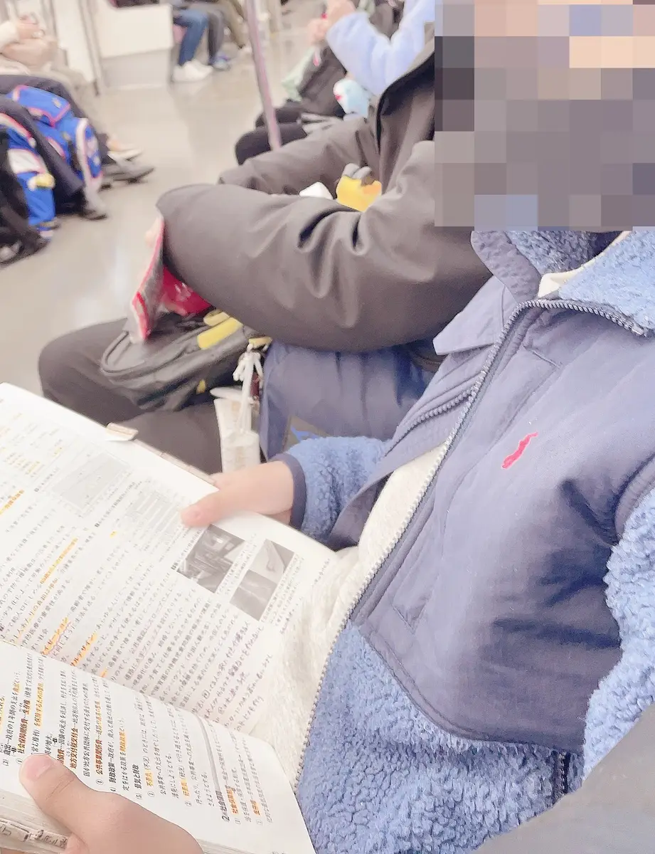受験当日、電車の中で参考書を読む息子