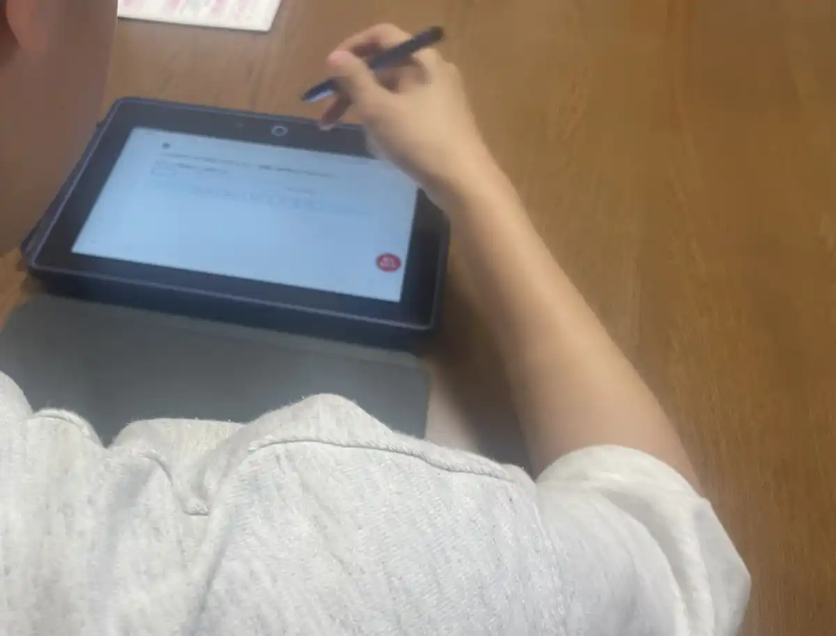 学習サービスのタブレットで勉強する息子の後ろ姿
